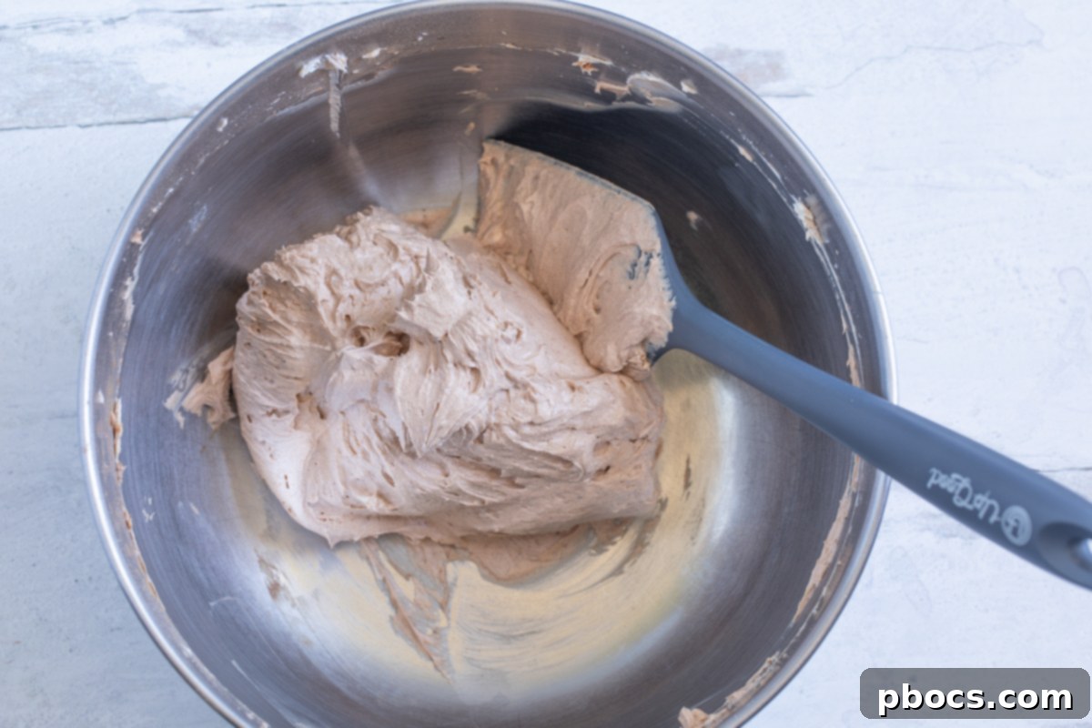 The chocolate fat bomb mixture in a mixing bowl after all ingredients have been combined, showing its uniform dark color.