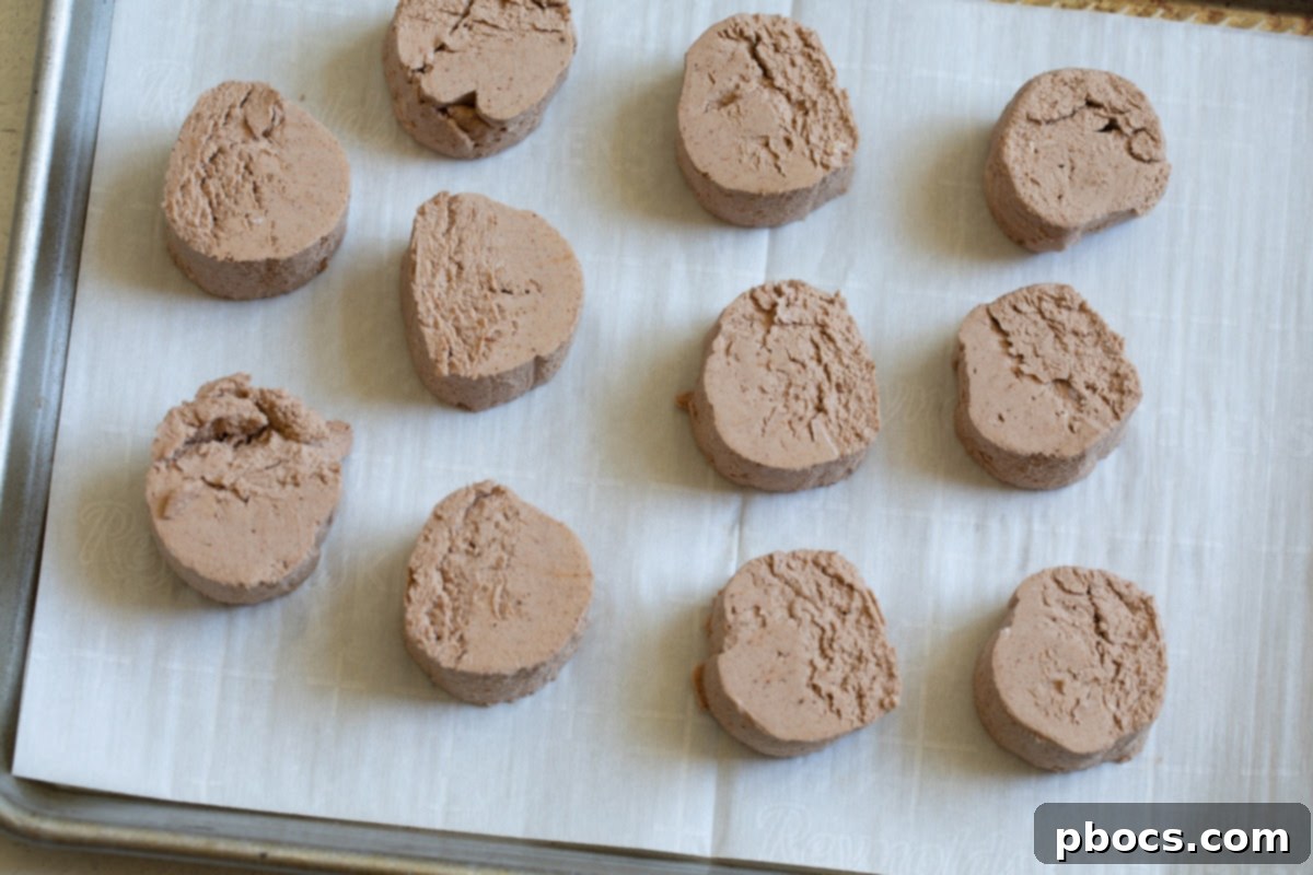 The chocolate fat bomb roll cut into individual circular pieces on parchment paper.