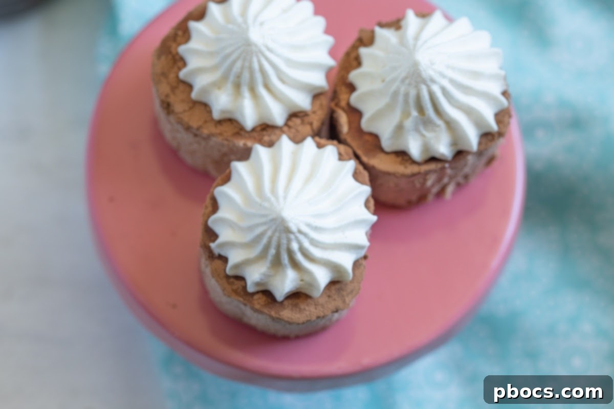 A trio of Keto Hot Chocolate Fat Bombs beautifully arranged on a white plate, with a background of baking ingredients and utensils.