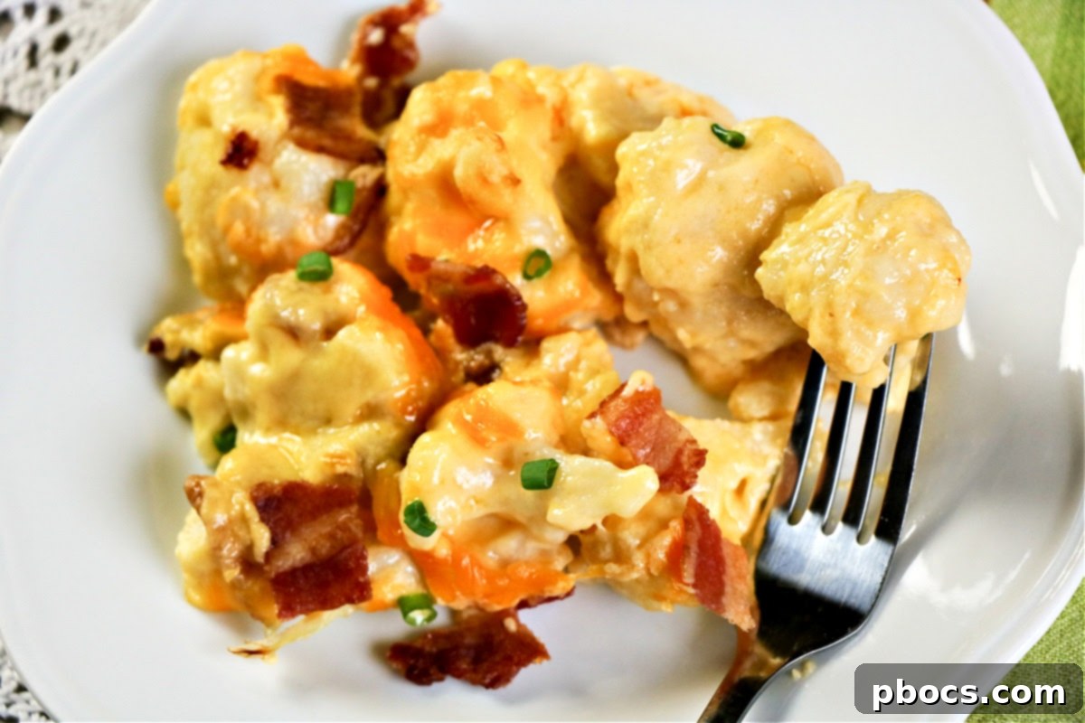 A vibrant casserole dish filled with unbaked Keto Cauliflower Au Gratin, topped with cheese and bacon.