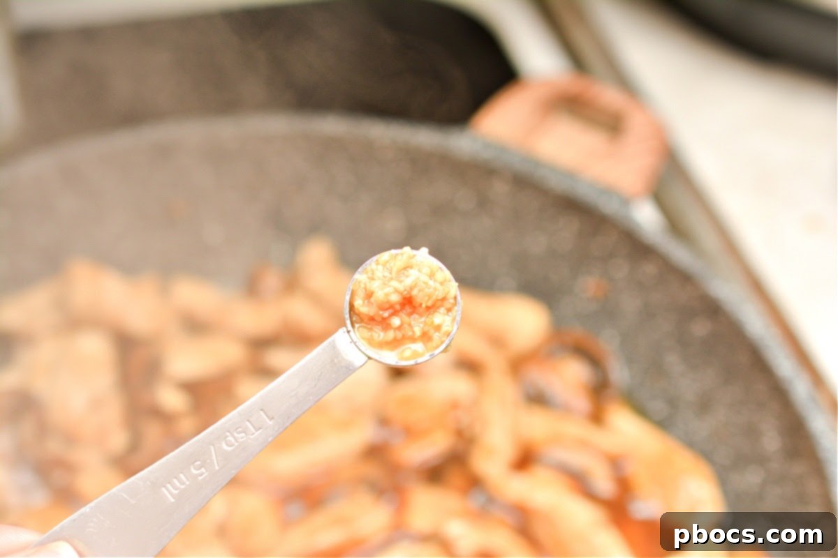 Keto Asian Mushroom Chicken Stir-fry 11 Garlic added to chicken and mushrooms in a skillet