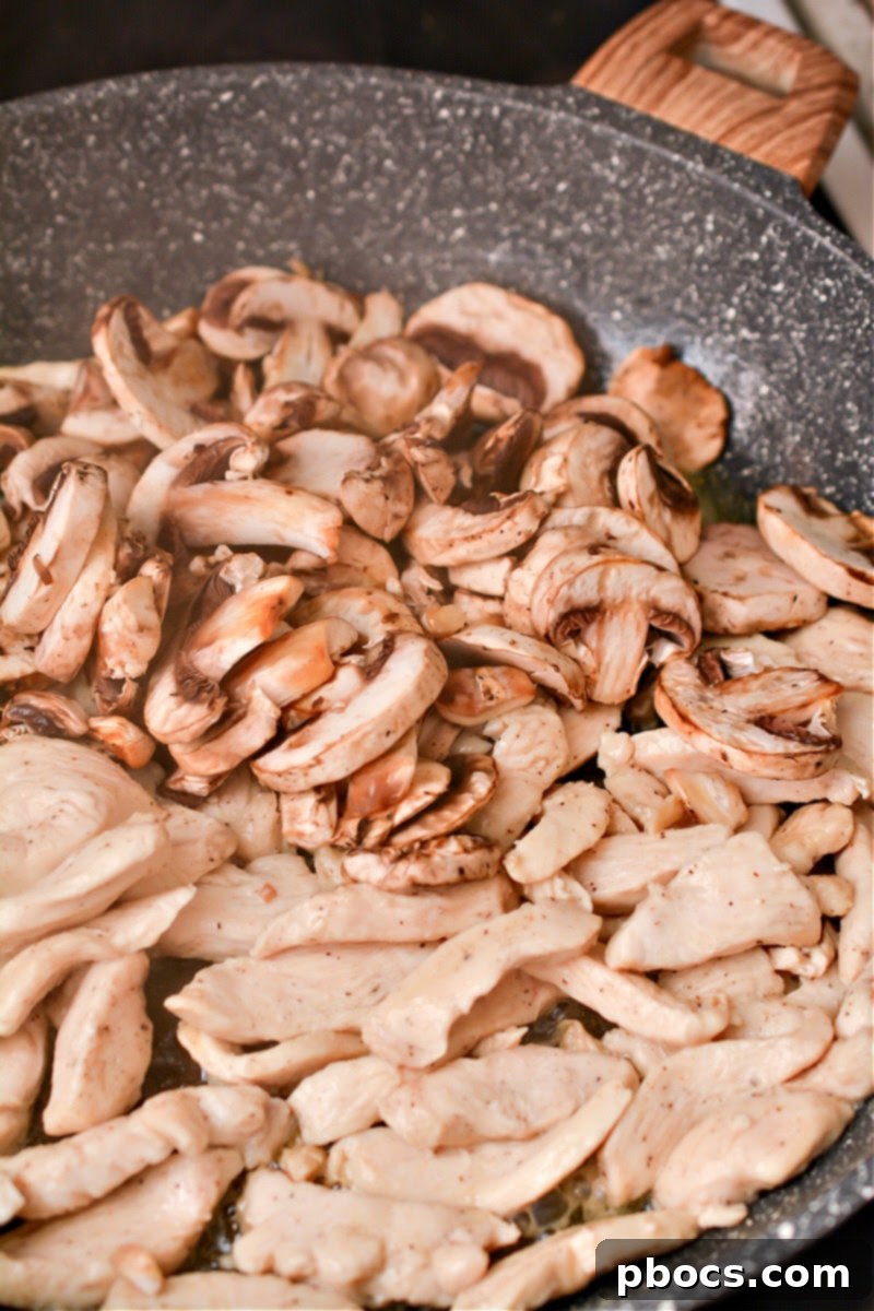 Keto Asian Mushroom Chicken Stir-fry 9 Mushrooms added to chicken in a skillet
