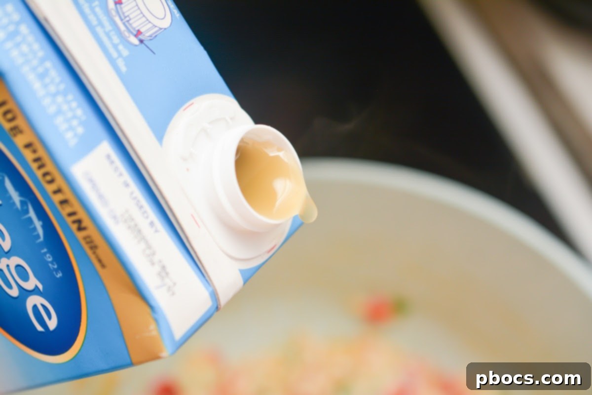 Creamy Keto Jalapeno Popper Soup 12 Chicken broth being slowly added to the soup base