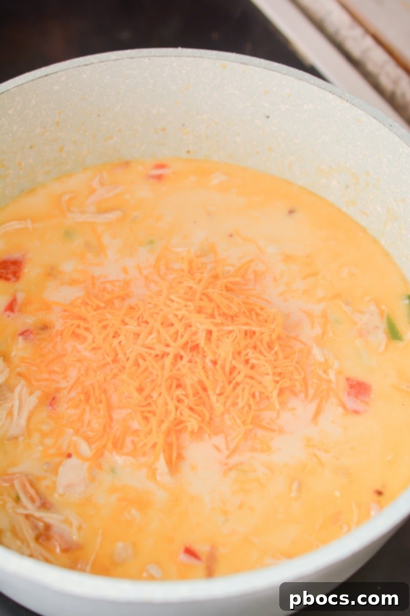 Creamy Keto Jalapeno Popper Soup 14 Shredded cheddar cheese melting into the simmering soup