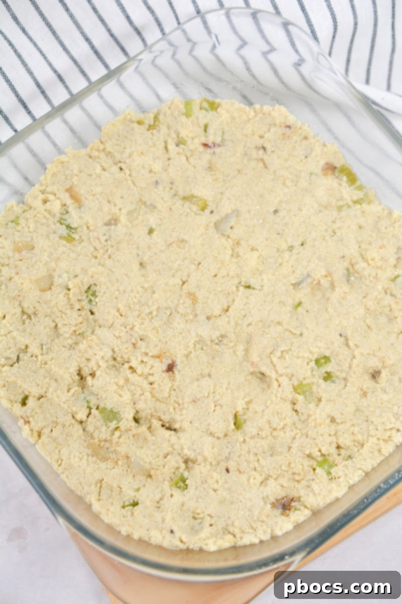Spreading keto cornbread dressing into a baking dish