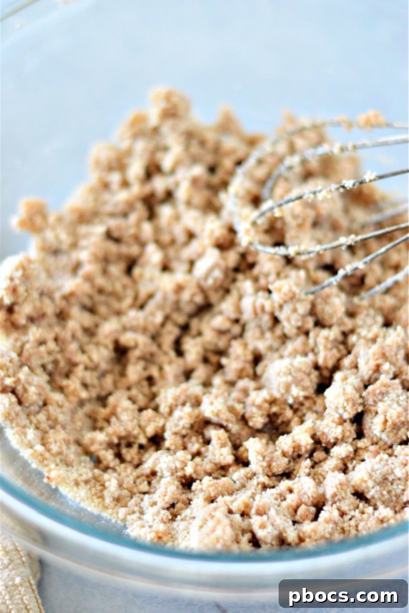 Pressing the keto crust into a parchment-lined pan for chilling