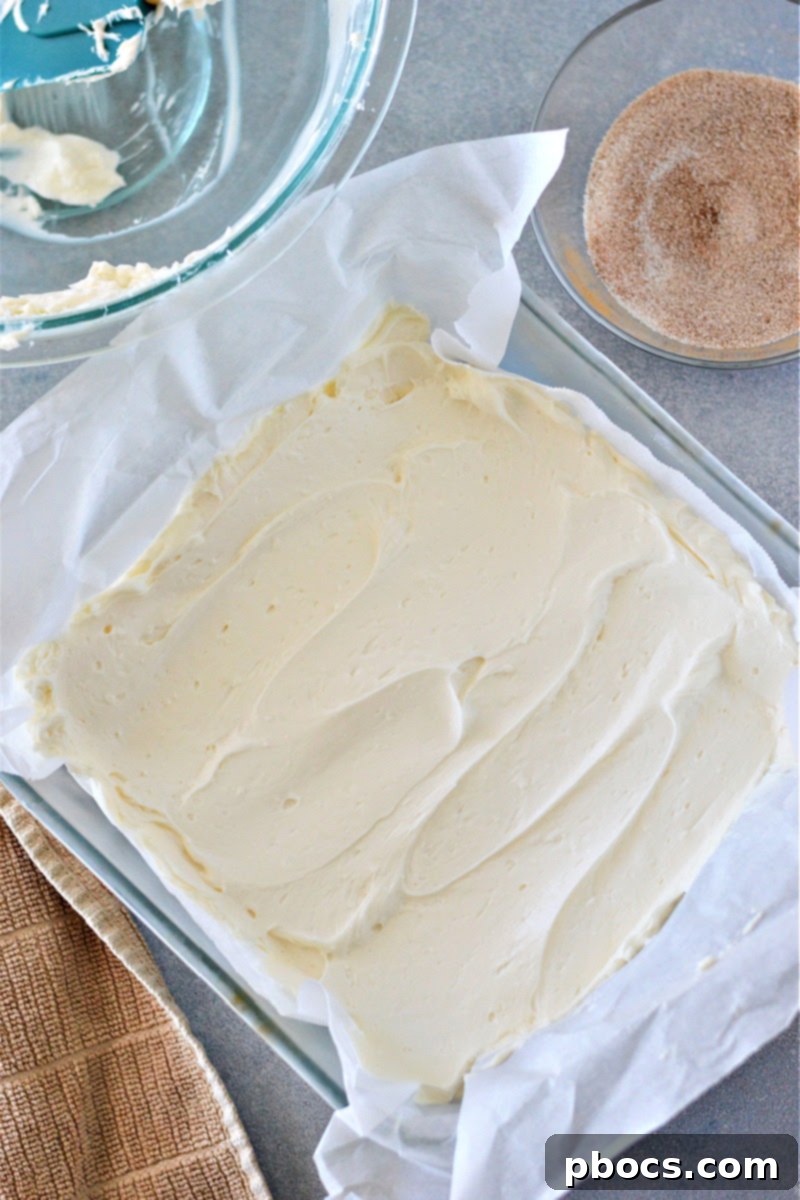 Sprinkling cinnamon-sugar topping on Keto No-Bake Churro Cheesecake Bars