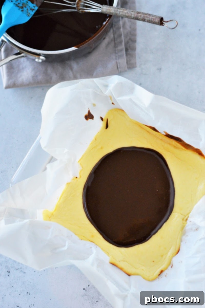 Pouring the melted chocolate ganache over the chilled cream filling.