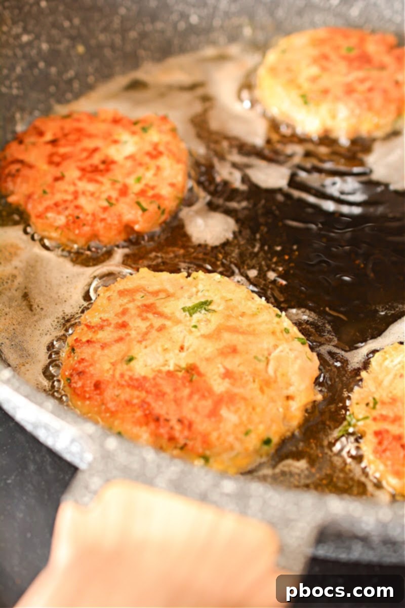 Heating oil in a skillet for frying Keto Cheesy Chicken Fritters