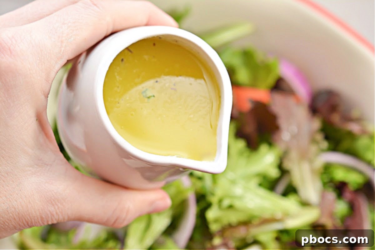 Close-up of the vibrant, fresh ingredients of a Keto Copycat Olive Garden Salad, showcasing crisp lettuce, red onion, tomatoes, and black olives.