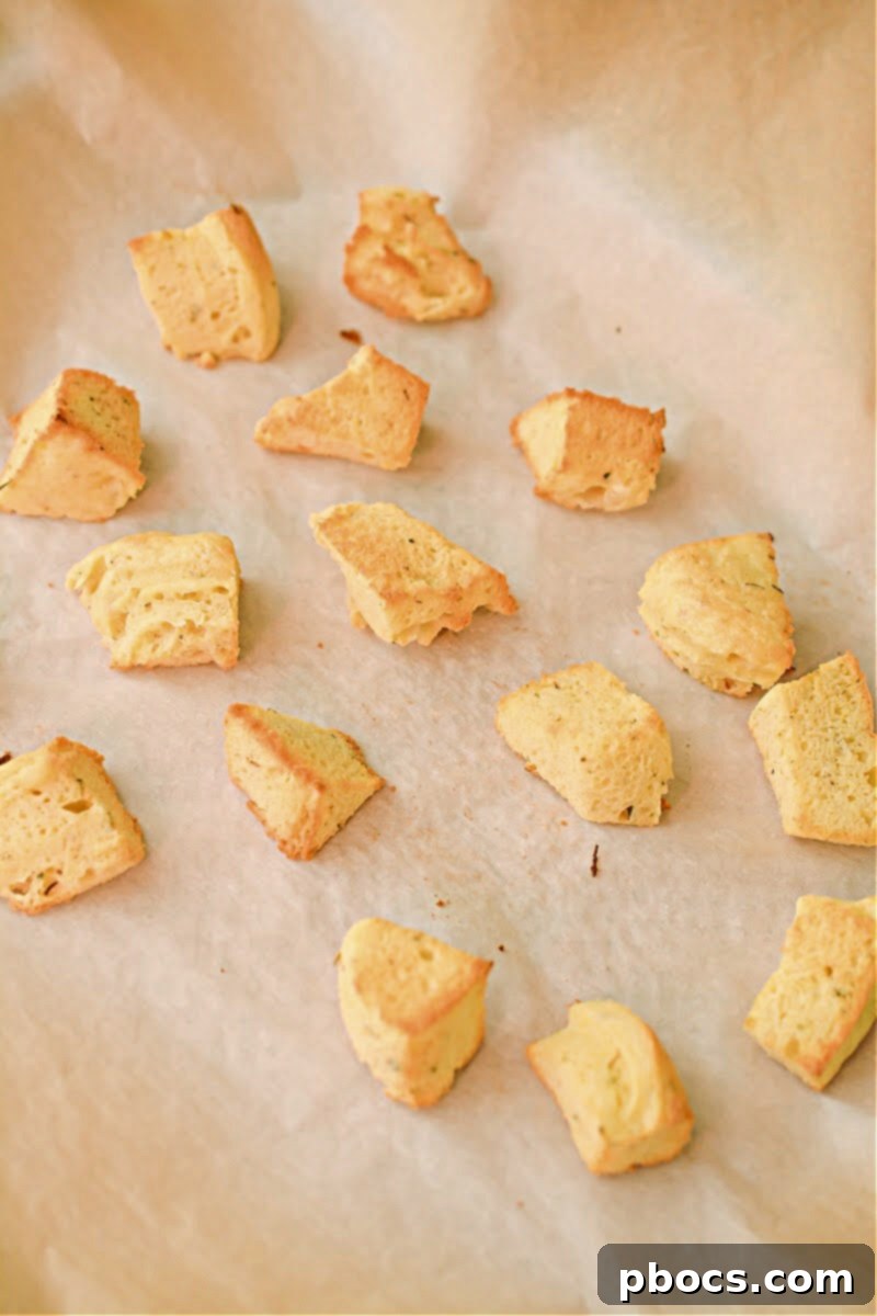 A small loaf of microwave-cooked keto bread, which will be cut into croutons, showcasing its light golden color.