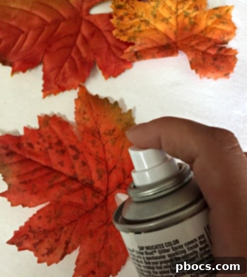 Spraying craft leaves with glitter for DIY garland
