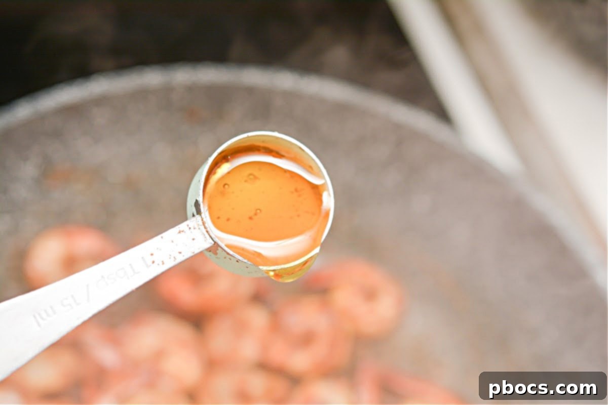 Shrimp cooking in butter in a hot skillet, turning pink and opaque.