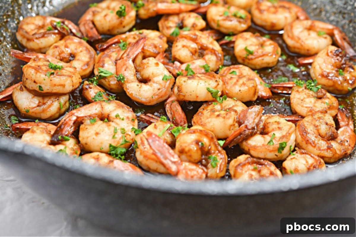 A pan of perfectly cooked Keto Honey Old Bay Shrimp, glistening with a sweet and savory glaze, ready to be served.