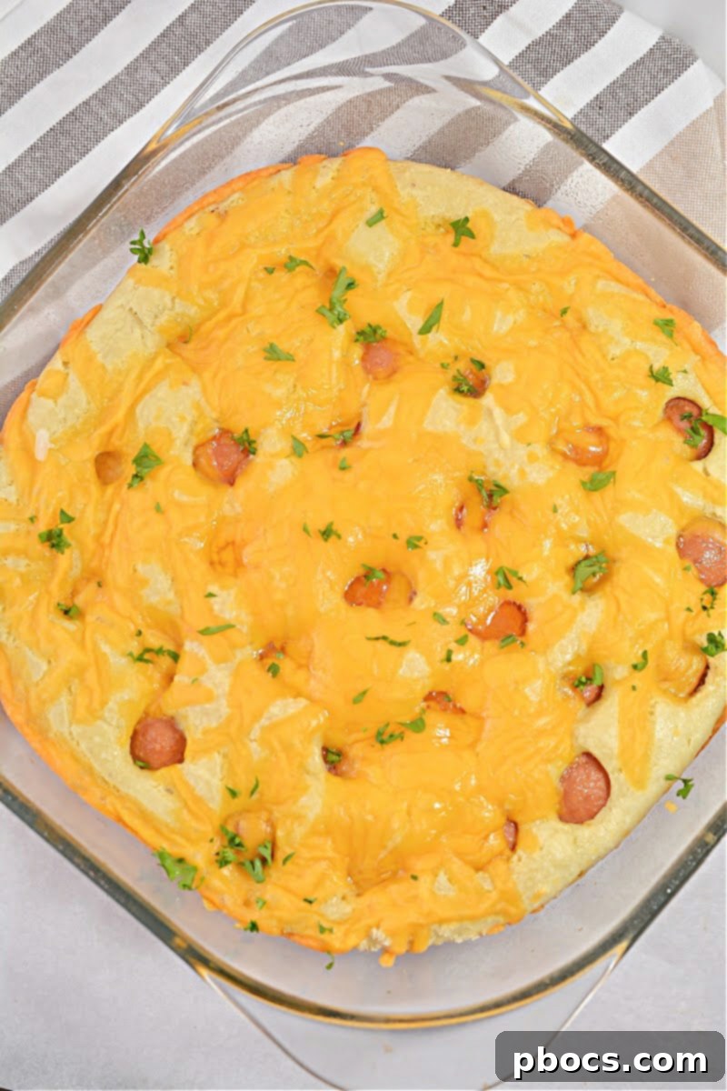 Sprinkling cheese on Keto Hot Dog Casserole
