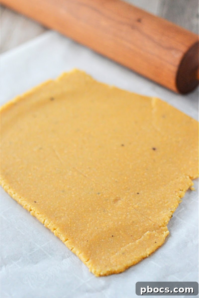 Keto Cheese Cracker dough being rolled out between parchment paper