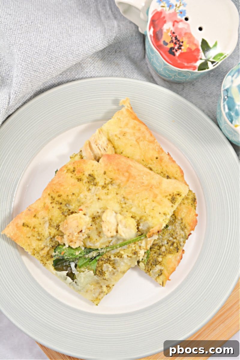 A serving of Keto Chicken Pesto Flatbread on a plate, showcasing its toppings and golden crust.