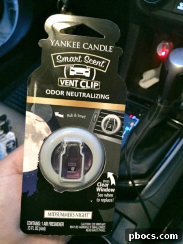 Close-up view of a Yankee Candle Car Jar Ultimate air freshener hanging in a car, exuding freshness