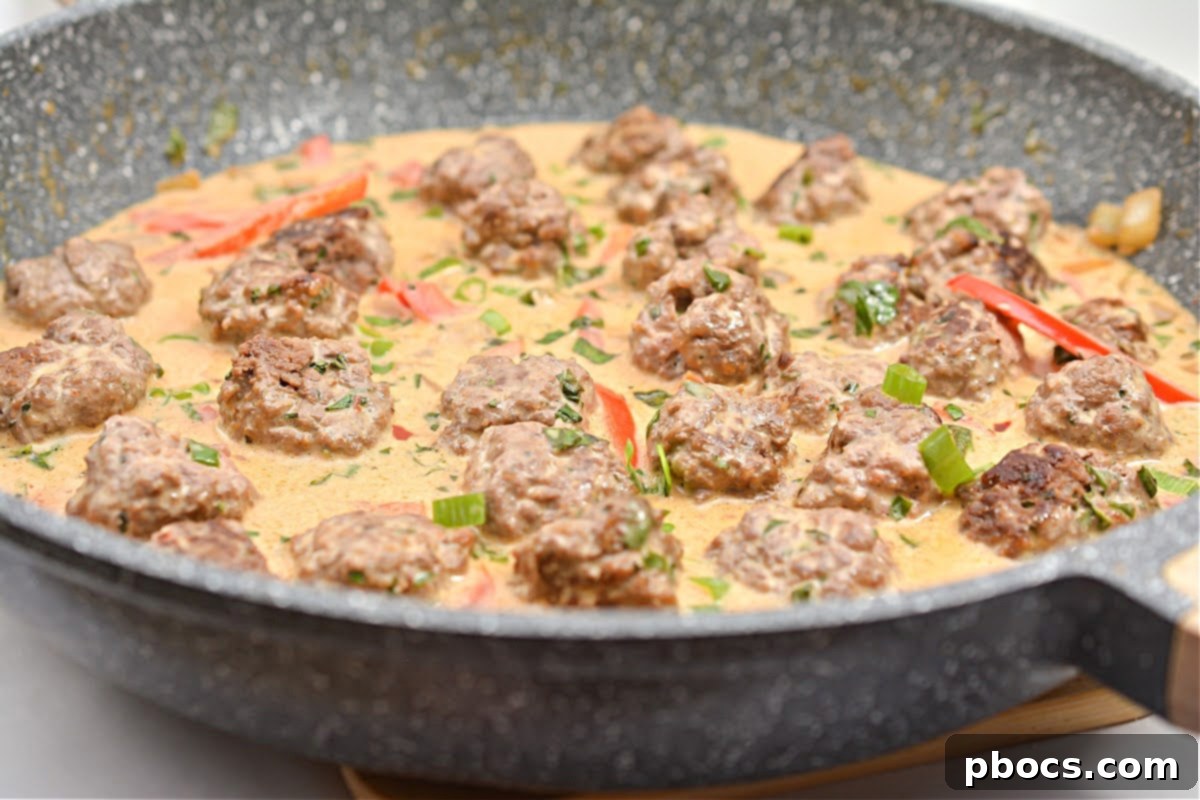 Spicy Keto Thai Meatballs 5 Coconut curry sauce simmering in a skillet
