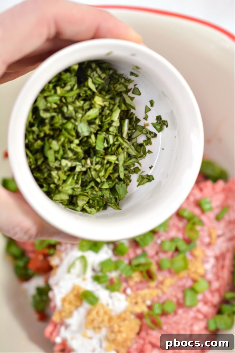 Spicy Keto Thai Meatballs 9 Mixing meatball ingredients by hand