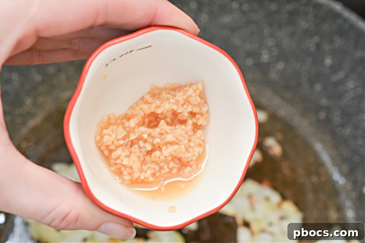 Keto Fiesta Pulled Pork Taco Casserole 9 Adding and sautéing garlic in a skillet for casserole base