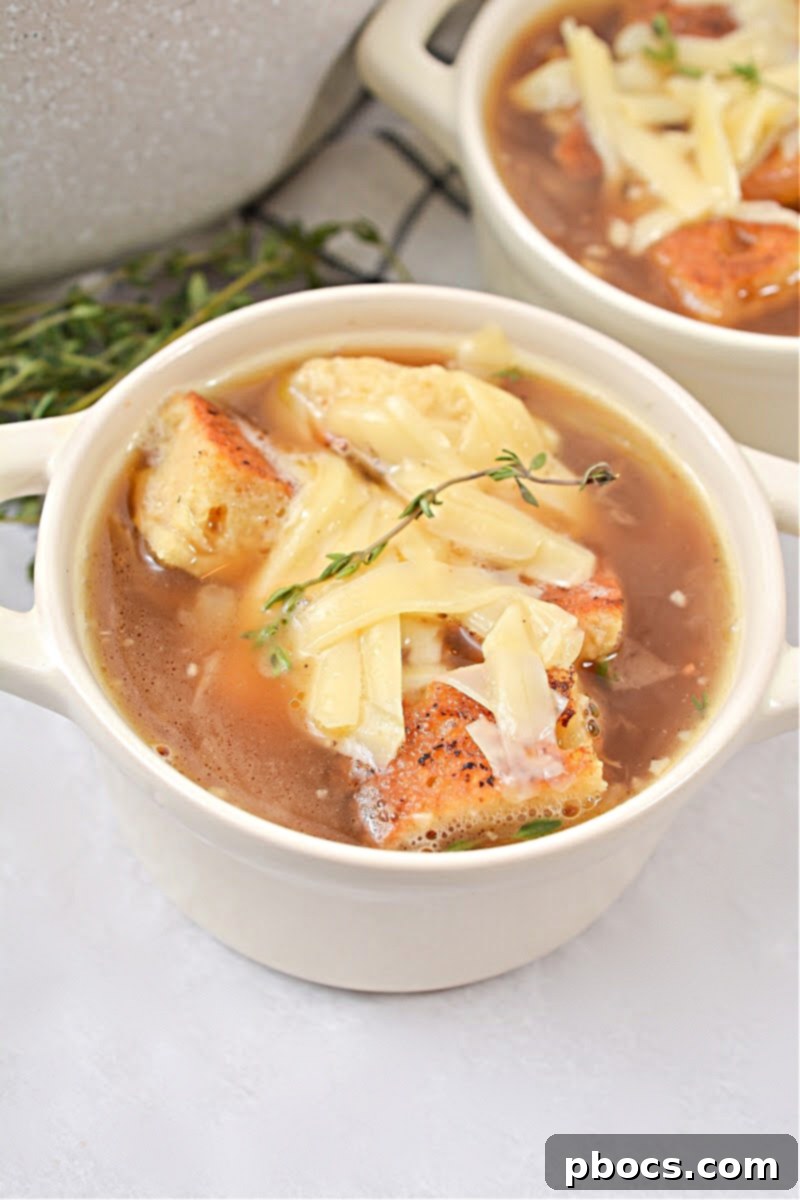 Keto French Onion Soup - a bowl of rich, savory broth with caramelized onions, low-carb croutons, and melted Gruyere cheese