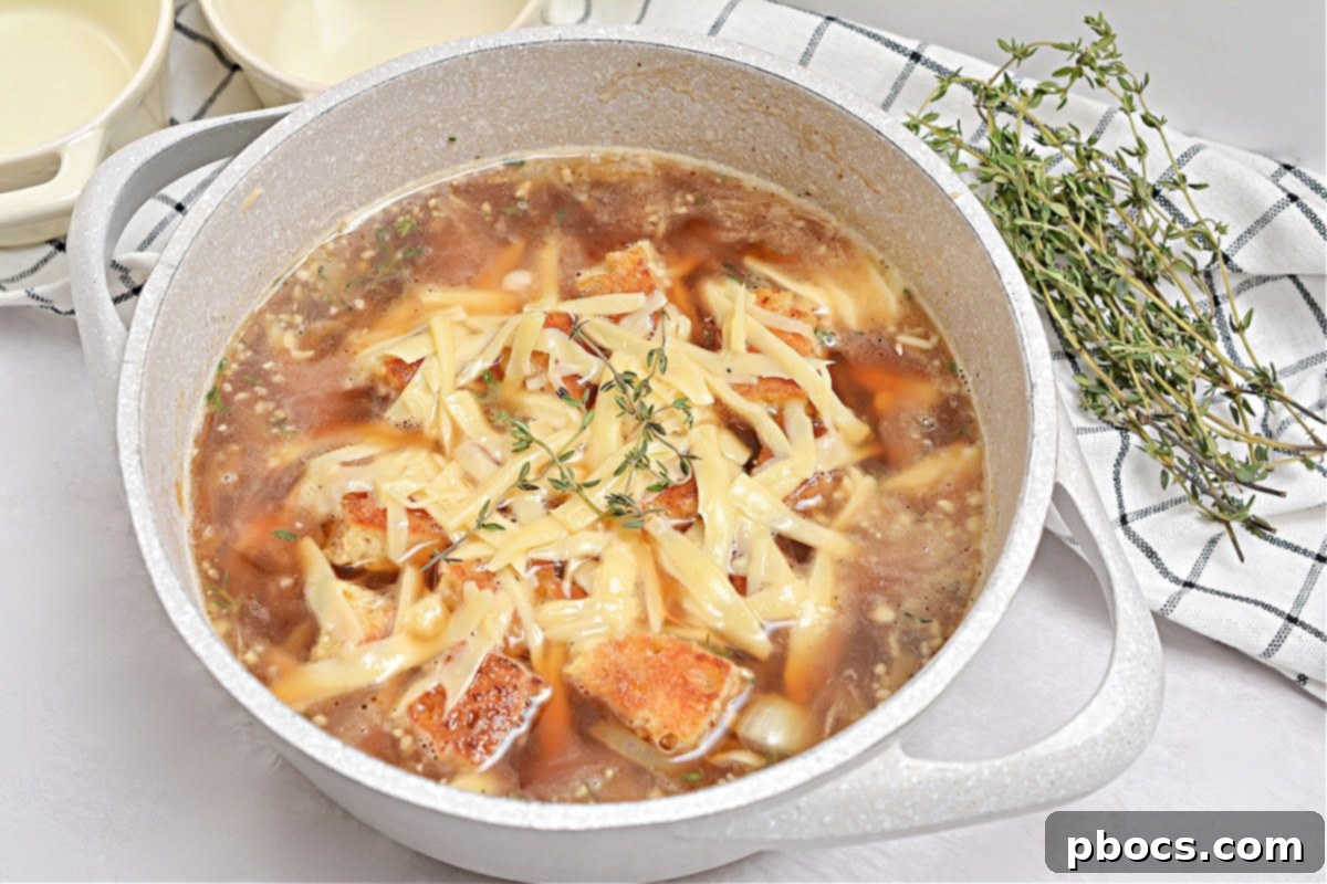 Serving Keto French Onion Soup with bread cubes and cheese