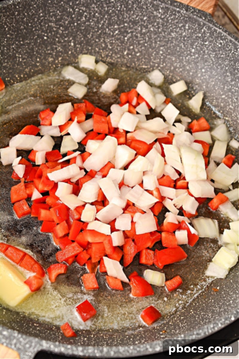 Butter melting in a skillet over medium heat, preparing the pan for sautéing vegetables.