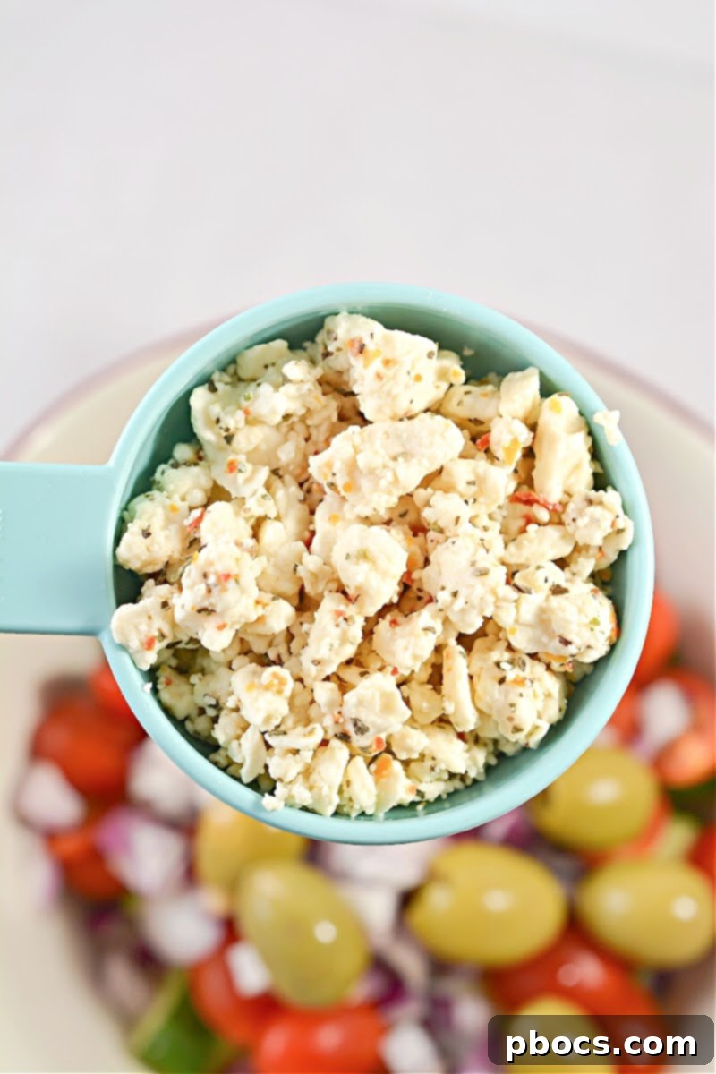 Mixing the vegetables and feta for Keto Greek Cucumber Salad