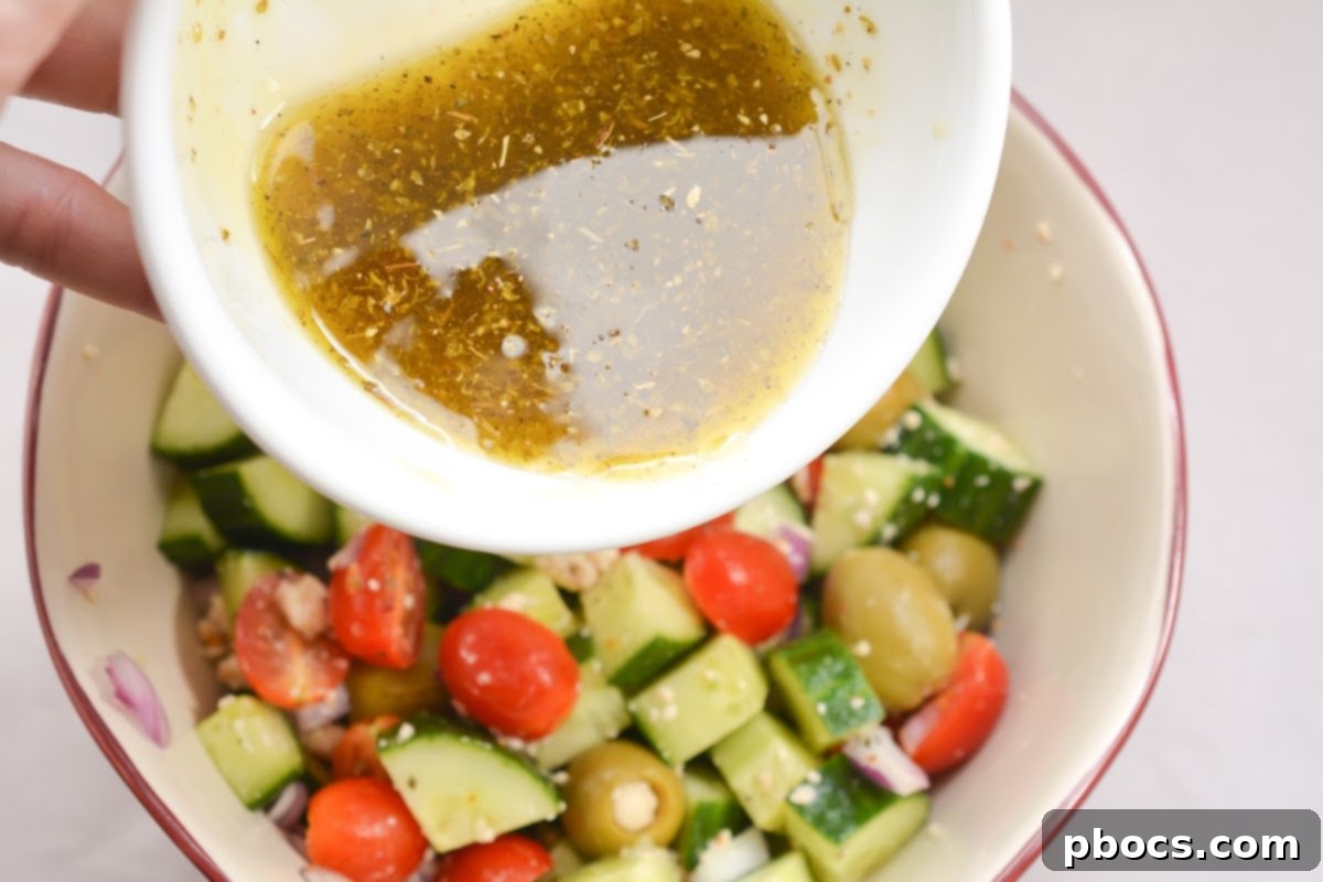 Tossing the Keto Greek Cucumber Salad with the dressing