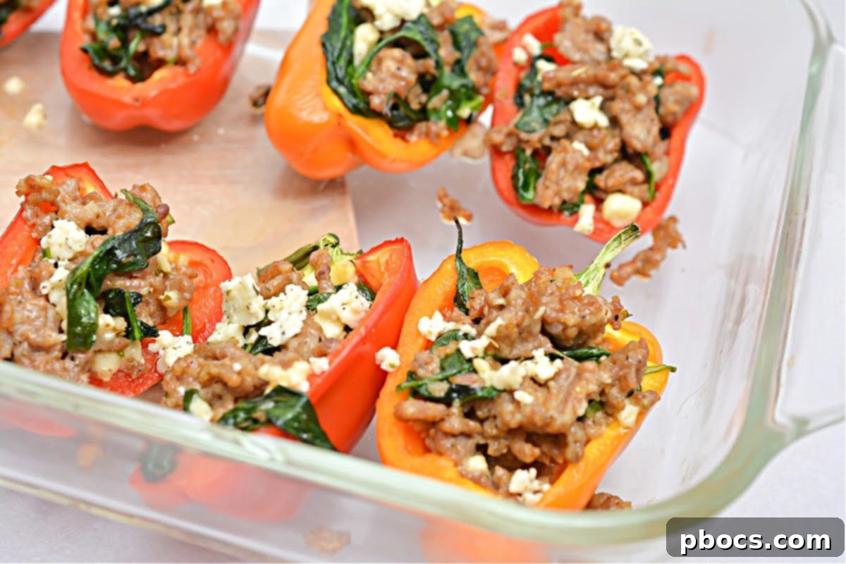 Hearty Keto Sausage Stuffed Bell Peppers 12 Mixing feta cheese with sausage and spinach filling