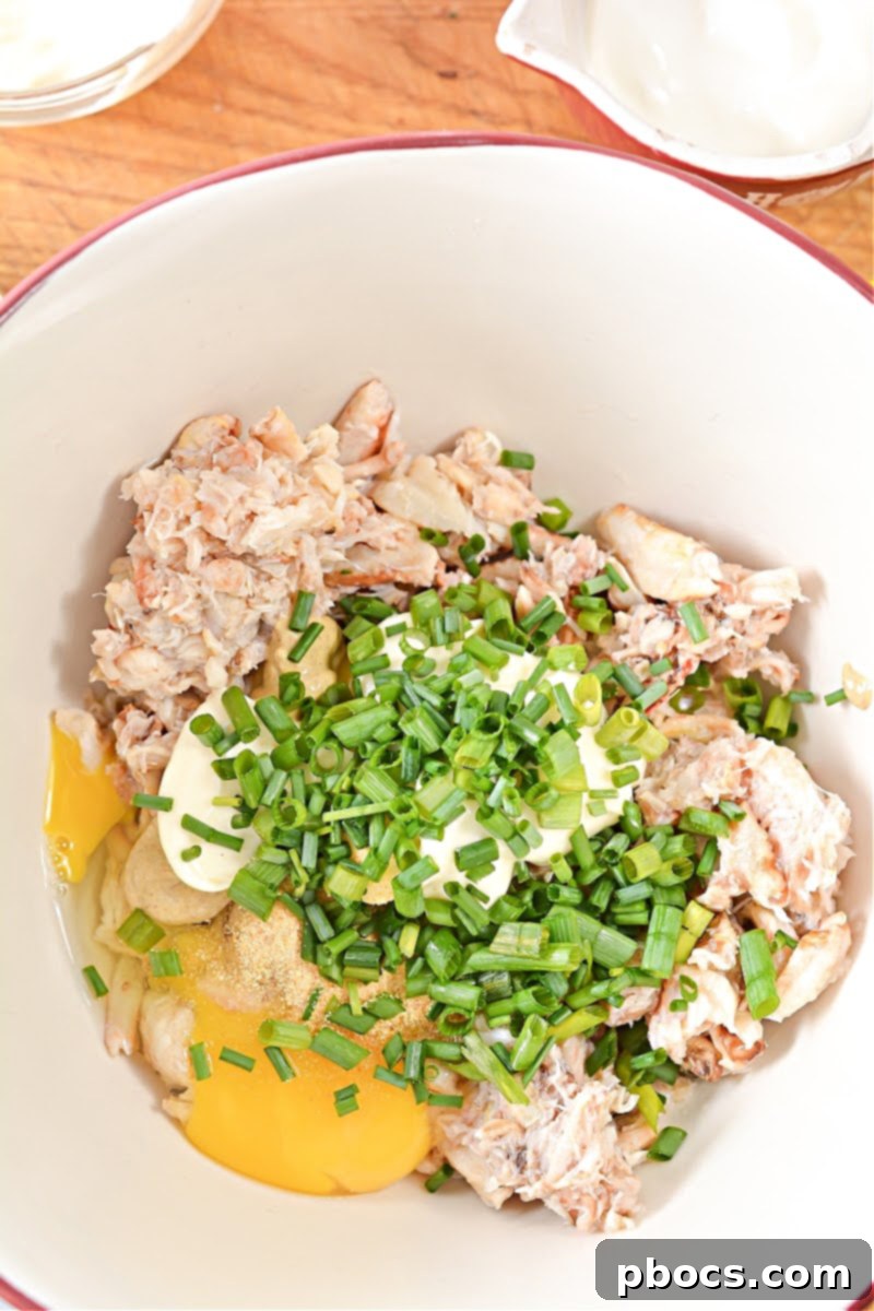 Combining ingredients for Keto Crab Cakes in a bowl.