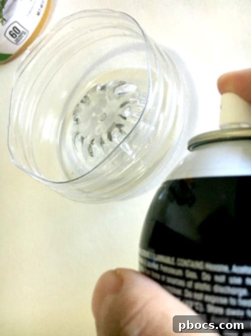 Applying adhesive spray for glitter on the V8 bottle