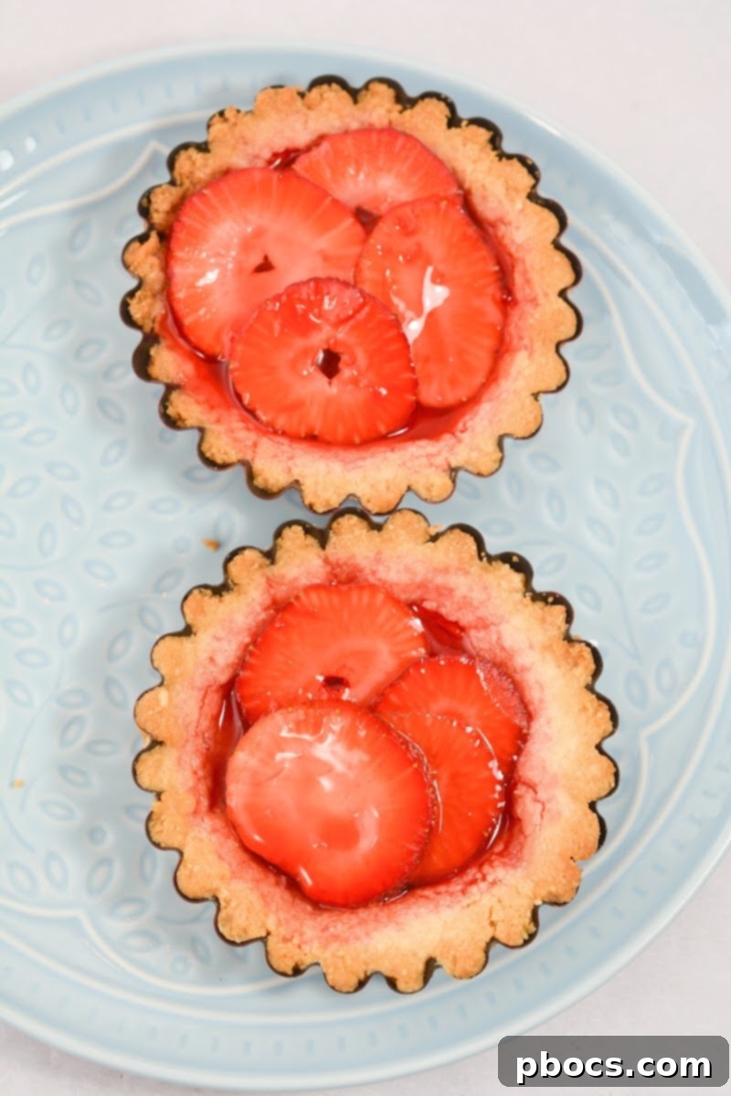 Delicious Keto Strawberry Mini Pies 14 Pouring strawberry Jello mixture over strawberries in pie crusts