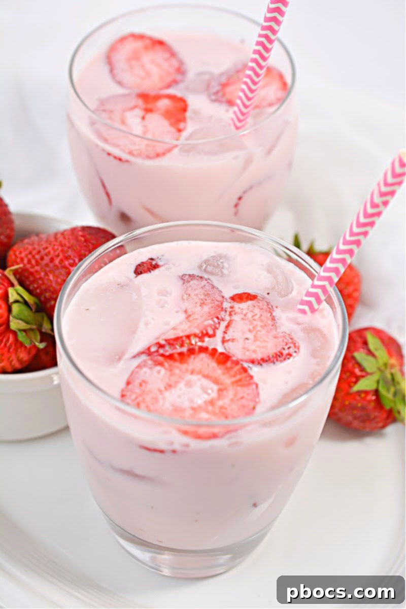 Frozen Keto Pink Drink garnished with fresh strawberries.