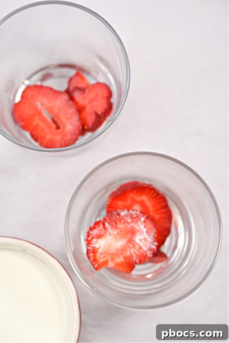 Step 1: Layering strawberry slices in cups for Keto Pink Drink.