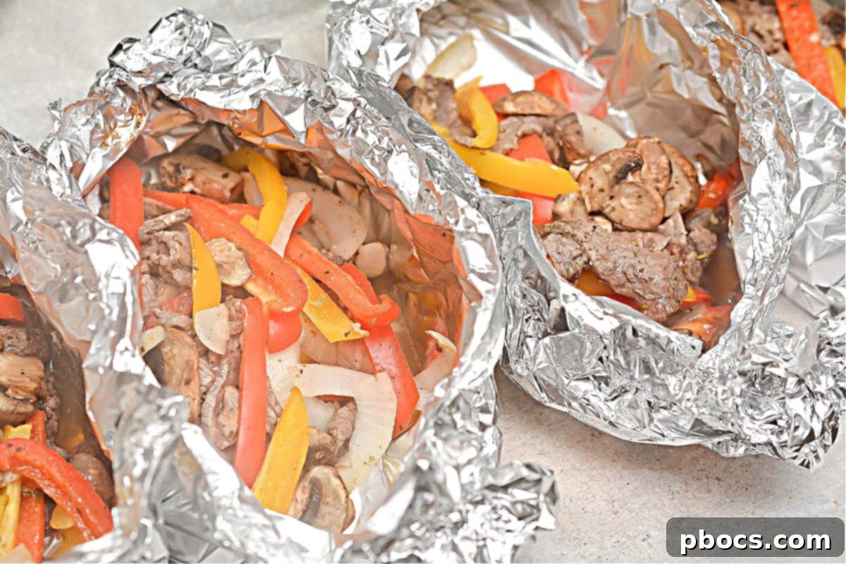 Adding cheese to hot Keto Philly Cheesesteak Foil Packets