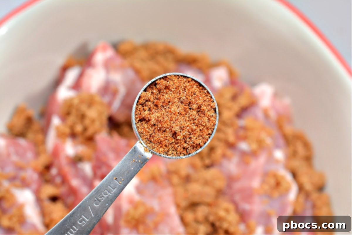 Cajun Keto Oven Ribs 9 Rubbing dry seasoning onto pork ribs