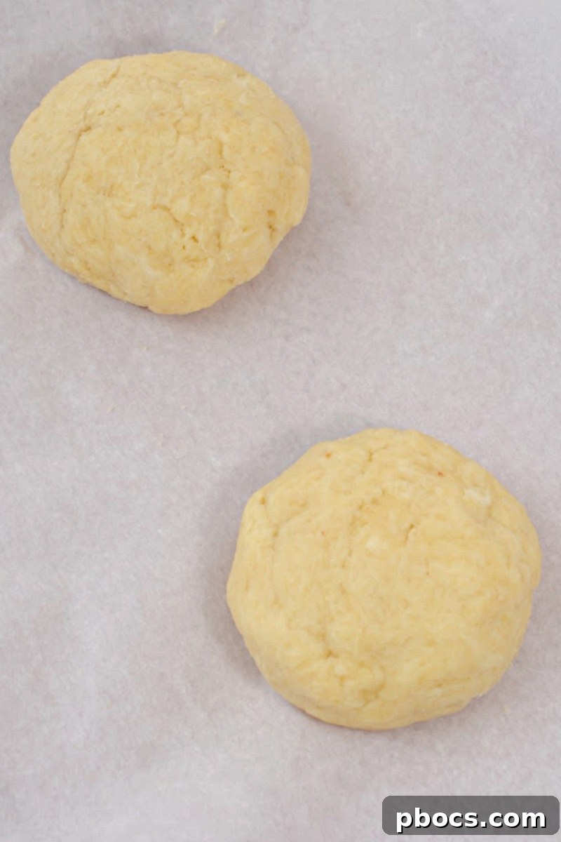 Freshly baked and browned keto bread bowls on a baking sheet, cooling after baking.