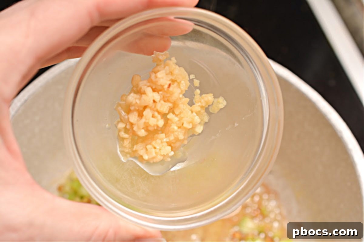 Chopped celery being sautéed in butter in a saucepan.