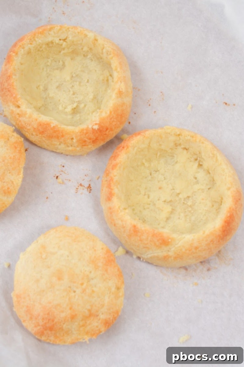 Close-up of a Keto Bread Bowl being hollowed out, showing the process of preparing it for soup.