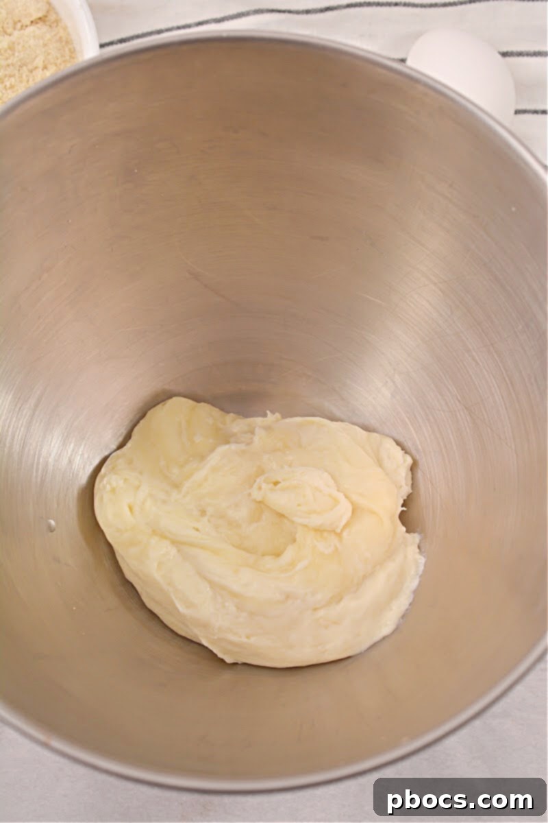 Mixing bowl with melted cheeses and dry ingredients for the keto bread dough, being blended until smooth.