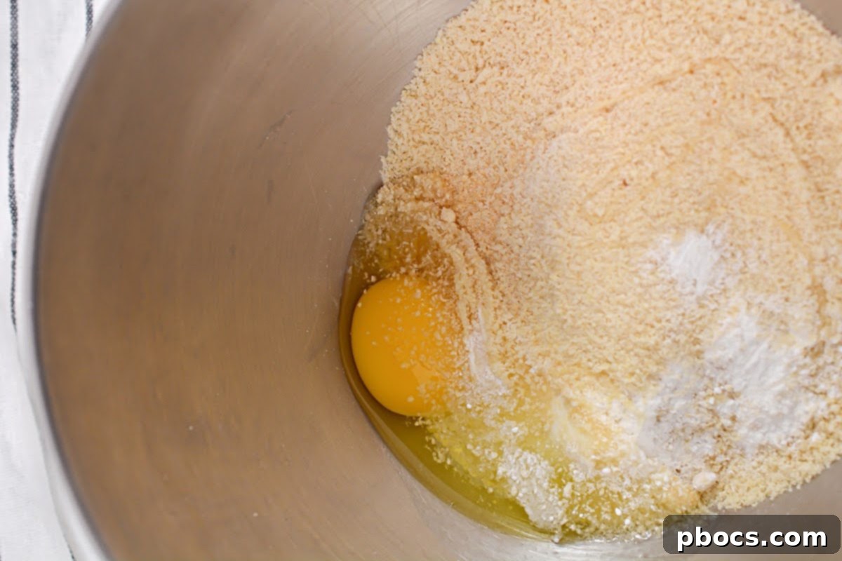 Two round keto bread dough portions formed on a baking sheet, ready for the oven.