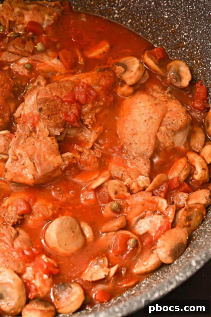 Adding diced tomatoes to the skillet