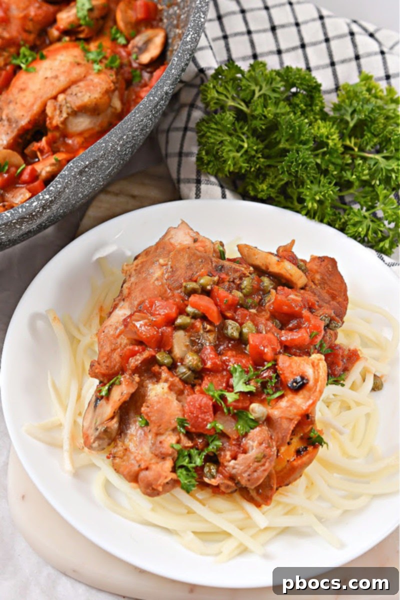 Keto Chicken Cacciatore simmering in a skillet with sauce