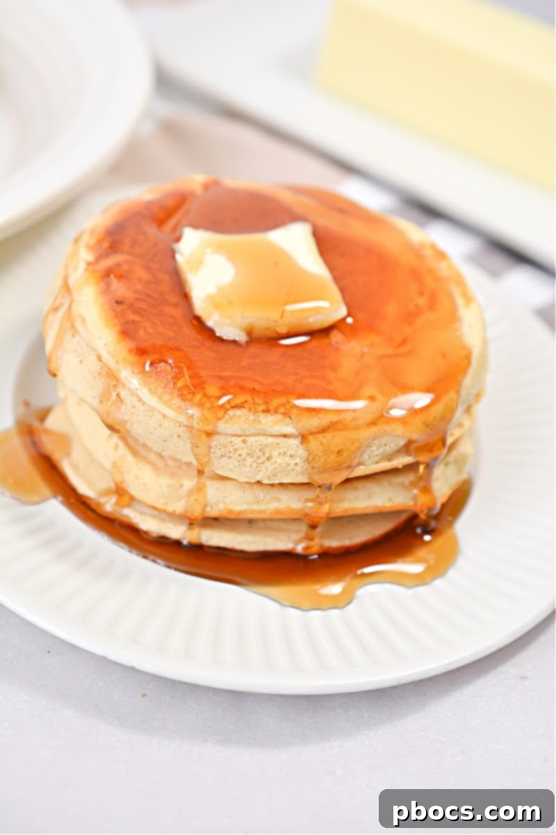 A Stack of Keto Protein Pancakes with Berries and Syrup