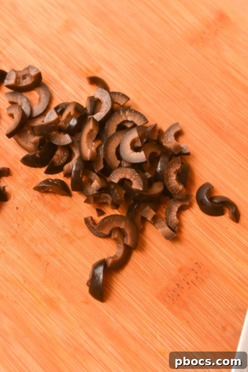 Keto Cucumber Web Bites 13 Step 6: Placing a whole black olive as the spider's body on each cucumber bite