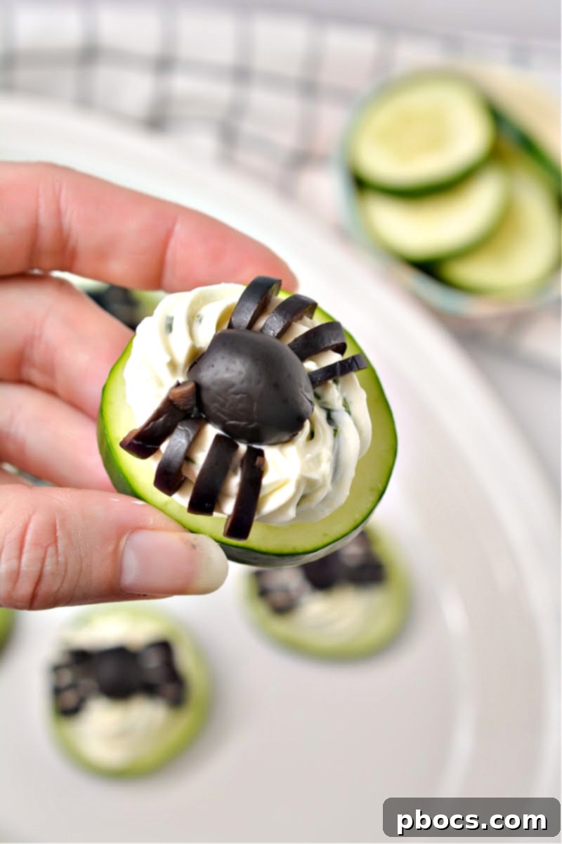 Keto Cucumber Web Bites 3 Close-up of Keto Spider Cucumber Appetizer Bites with black olive legs on a serving plate