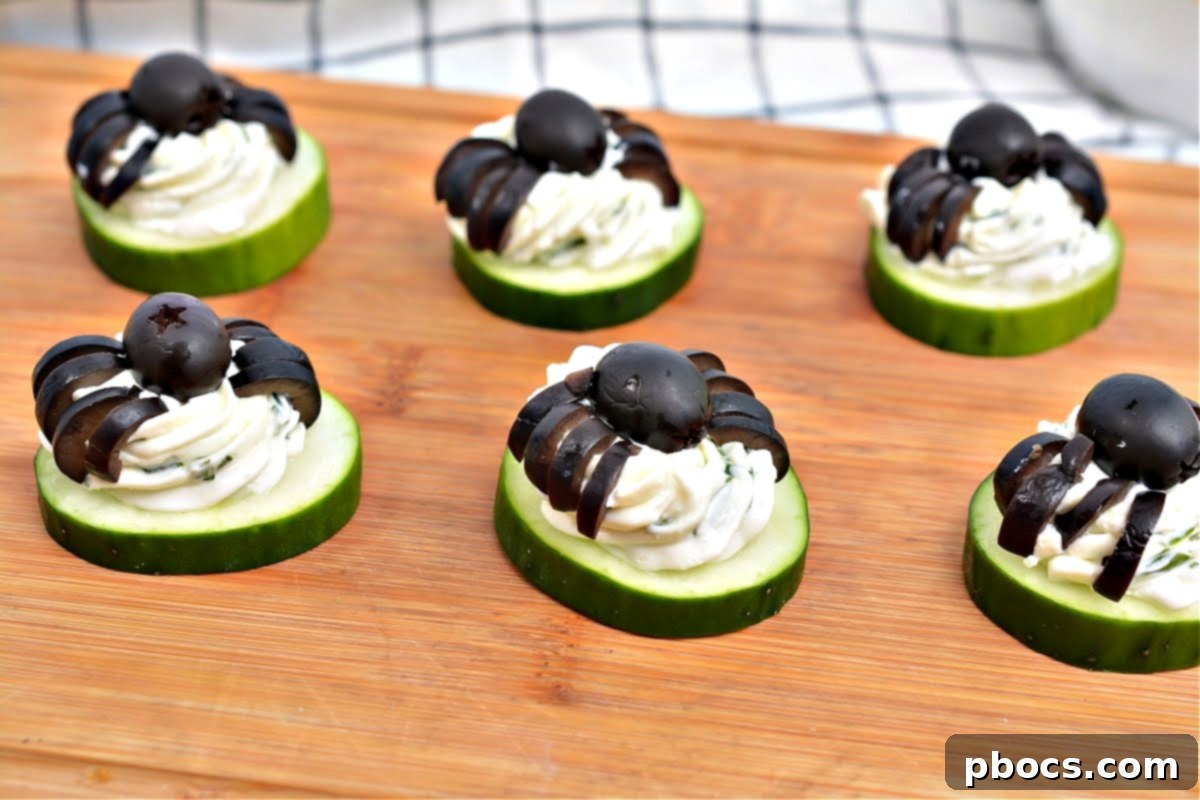 Keto Cucumber Web Bites 6 Assembling Keto Spider Cucumber Appetizer Bites, showing olives being placed on cream cheese