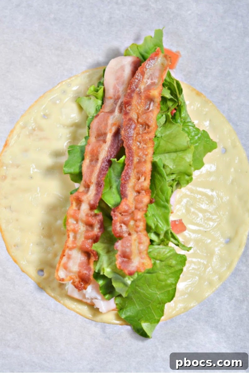 Keto Club Pinwheels 11 Keto Club Sandwich Roll Ups - Rolling the filled cheese wrap.